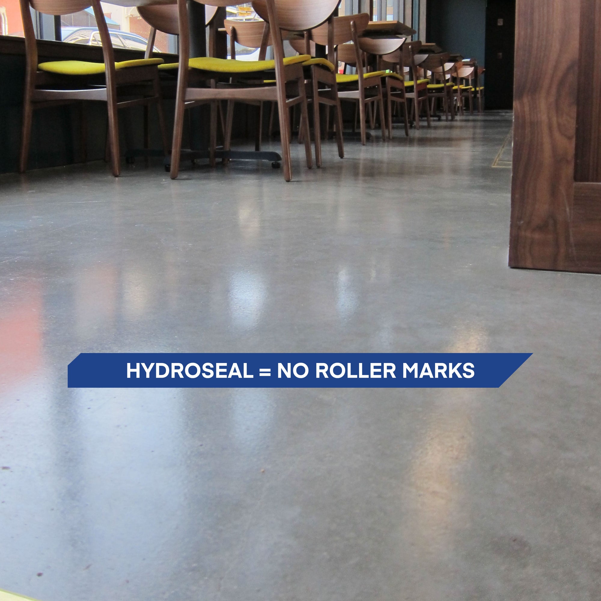 Gray concrete floor sealed with HydroSeal waterborne epoxy, showing a smooth, uniform, roller mark–free finish with professional gloss.